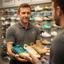 Vaj Inusah helping a customer compare football boots inside the Norwich shop