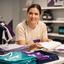 Catriona Brodribb arranging football shirts and printing samples in the shop